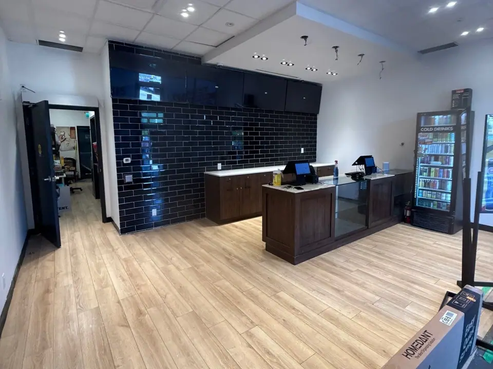 Retail store sales floor with wood-look flooring and a tiled feature wall after the final clean